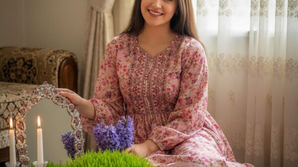 پرتره نوروزی دختر جوان کنار سفره هفت‌سین با گل سنبل